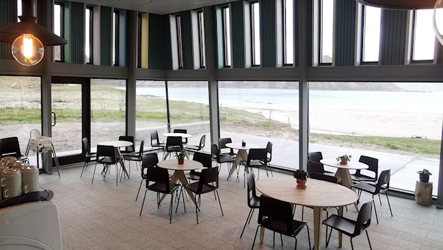 Café mit Blick auf Sandstrand und Berge.