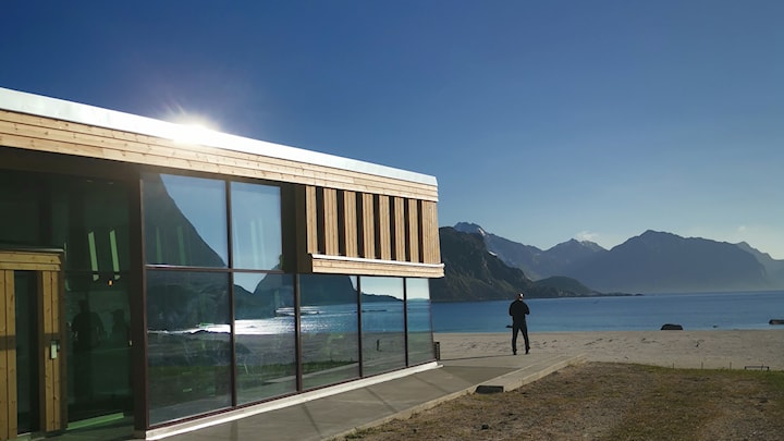 Naturen speiler seg i glassfasaden på bygget. 