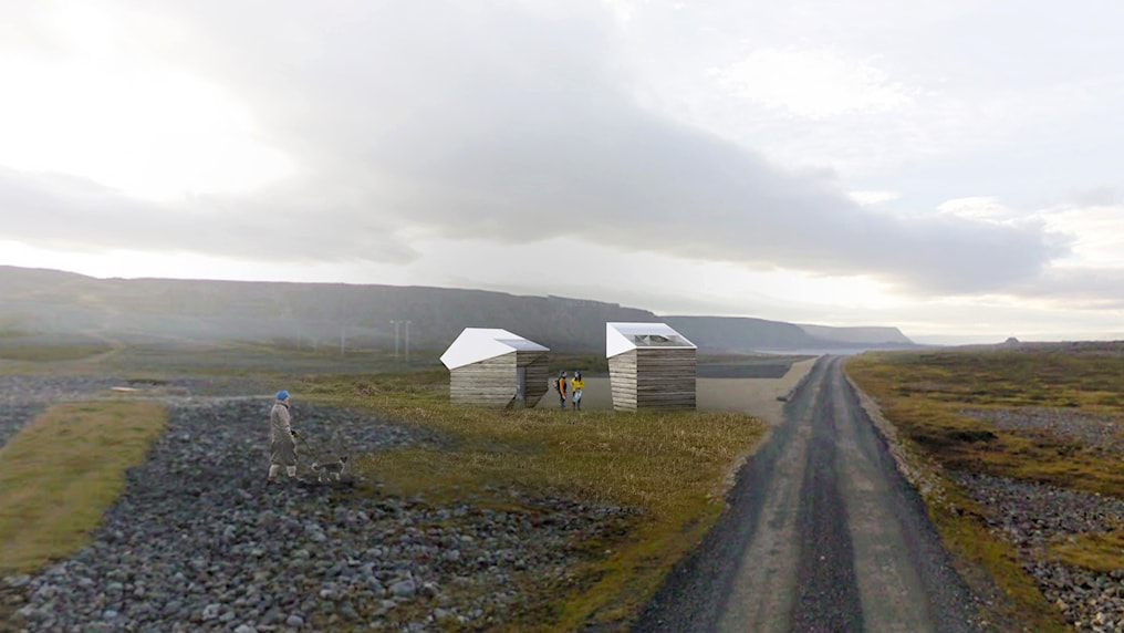  Two small service houses/toilets in open landscape by gravel road.