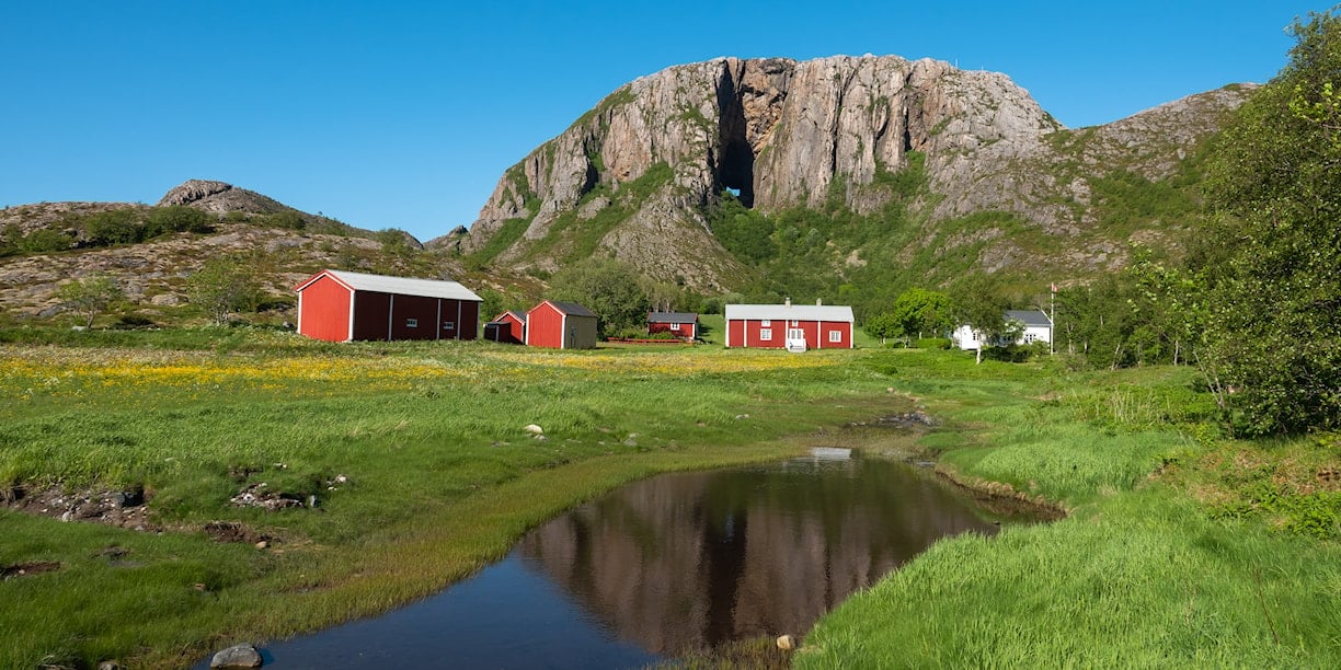 Et gårdsbruk i forkant av fjellet Torghatten.