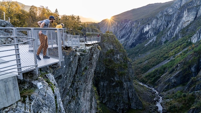 To menn ser over kanten på utsiktspunktet ved juvkanten.