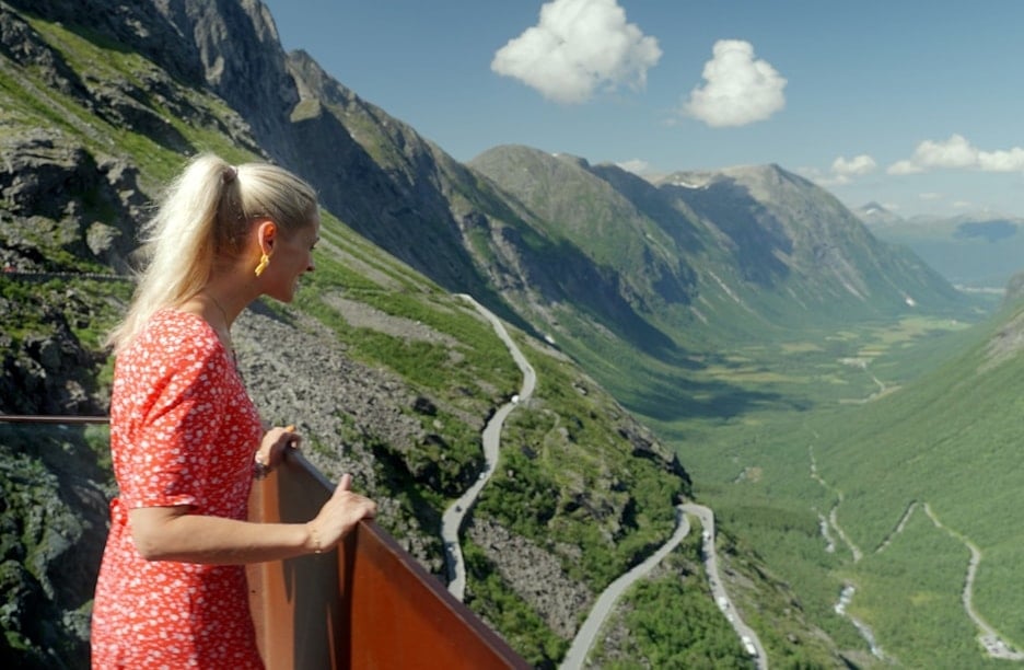 Ei kvinne nyt utsikta frå eit utsiktspunkt i Trollstigen.