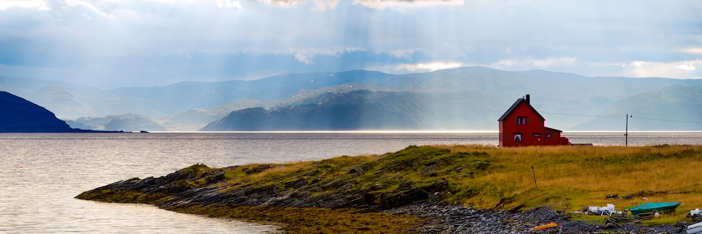 Fjorparti med enslig hus ved fjorden.