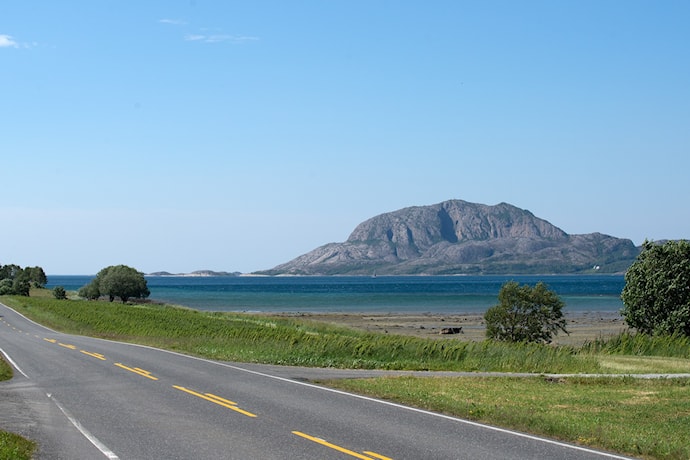 Turistveg med hav og fjellet Torghatten i det fjerne.