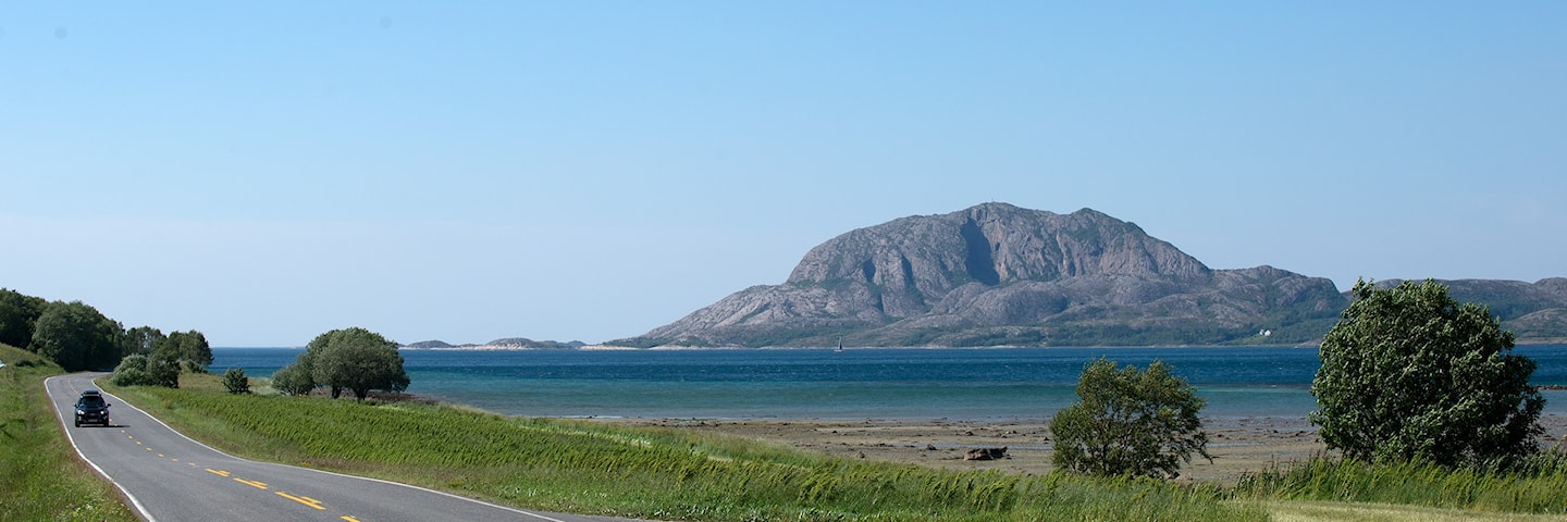 Turistveg med hav og fjellet Torghatten i det fjerne.