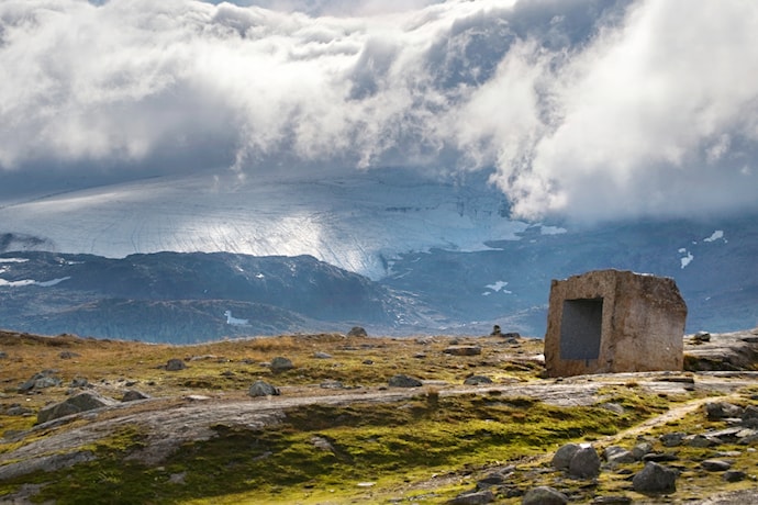 Skyfront med tåke kommer inn over Sognefjellet. Bildet viser Knut Wolds kunstinstallasjon ved Mefjellet rasteplass ved Nasjonal turistveg Sognefjellet.