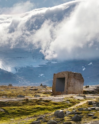 Skyfront med tåke kommer inn over Sognefjellet. Bildet viser Knut Wolds kunstinstallasjon ved Mefjellet rasteplass ved Nasjonal turistveg Sognefjellet.