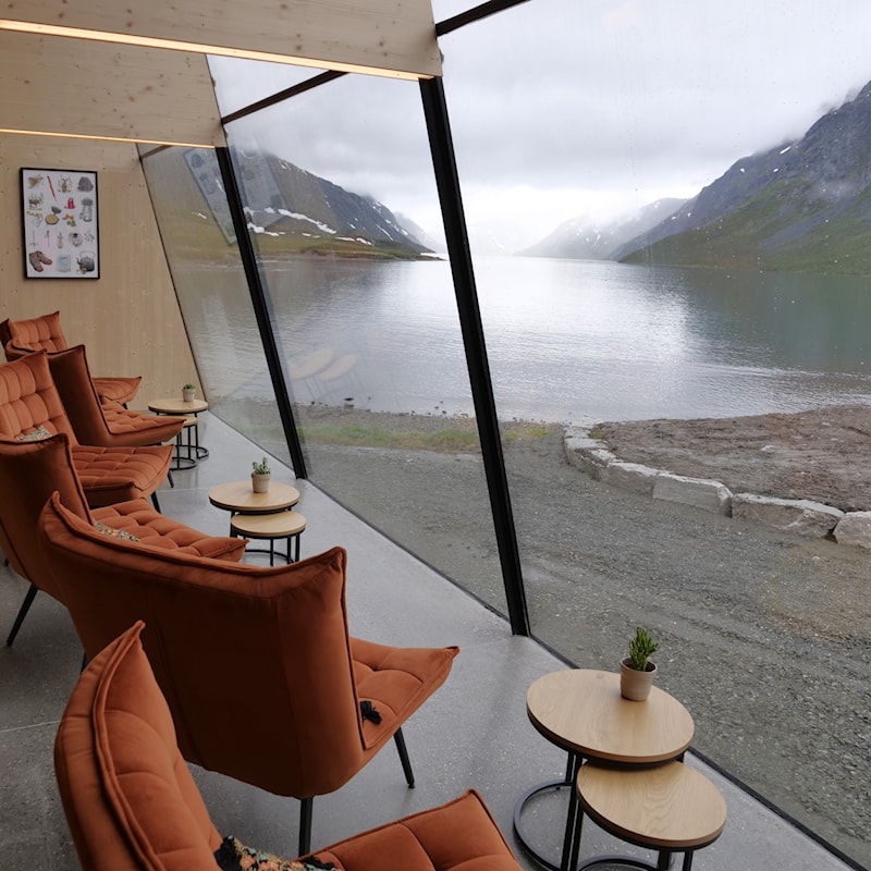 Hvilestoler i  kafeen med utsikt til innsjøen Gjende og fjellene.