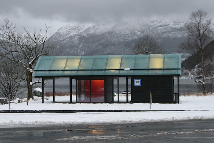 Toalettbygget i vinterlandskap.