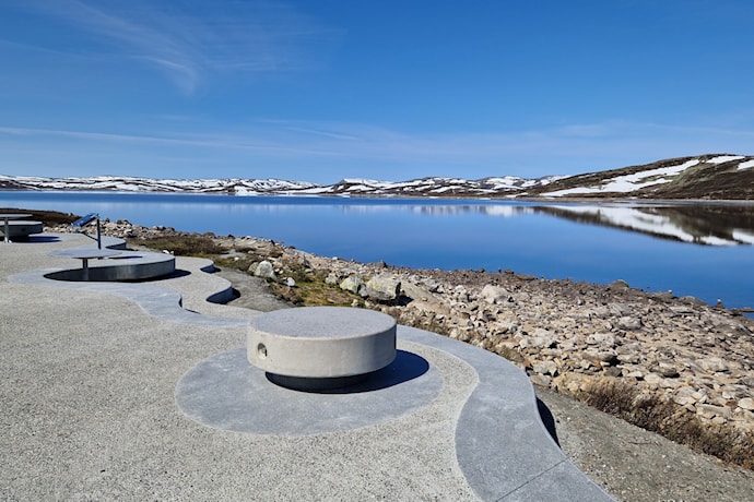 Rastemøbler i betong med utsikt til innsjøen Ørteren.