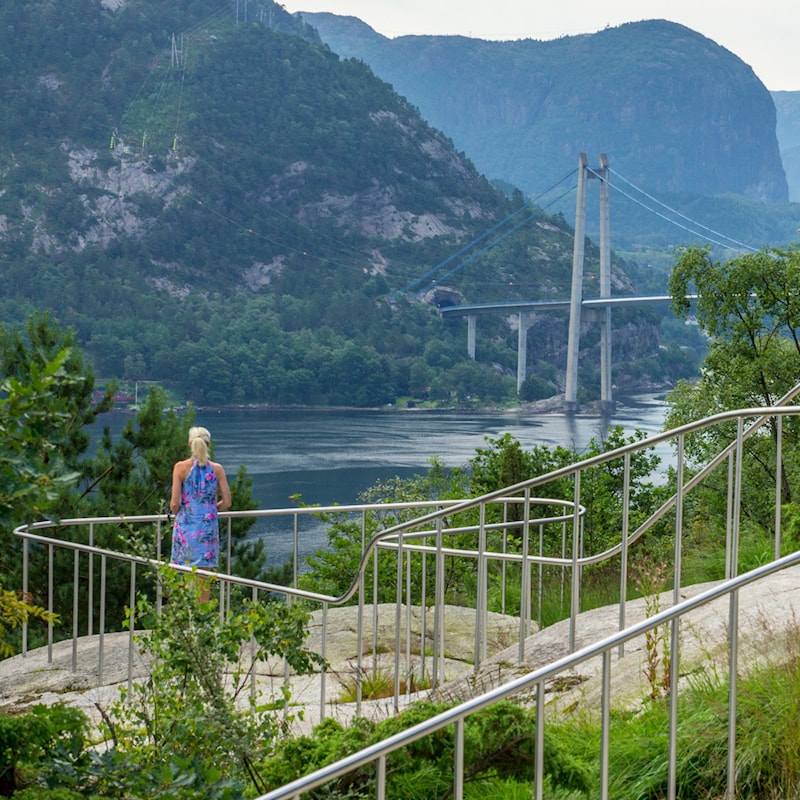 Rekkverk til utsiktspunkt. Utsikt utover Lysefjorden med brua fra Ryfylkevegen over til Forsand.