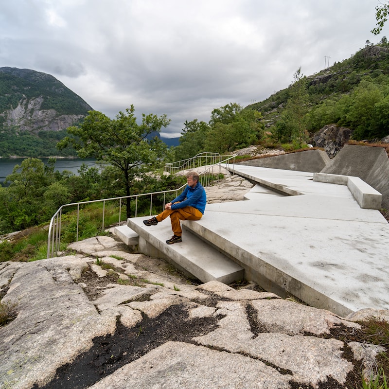 Betongplate med trapper til terreng og sittebenker.
