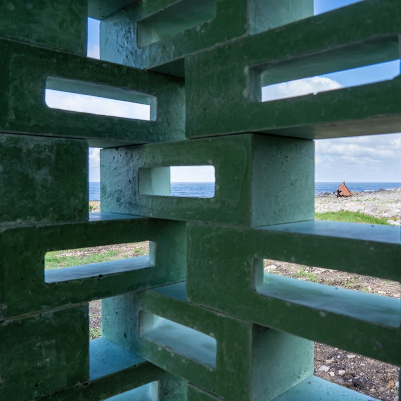 Ruskevær og sjøsprøyt mot molo.